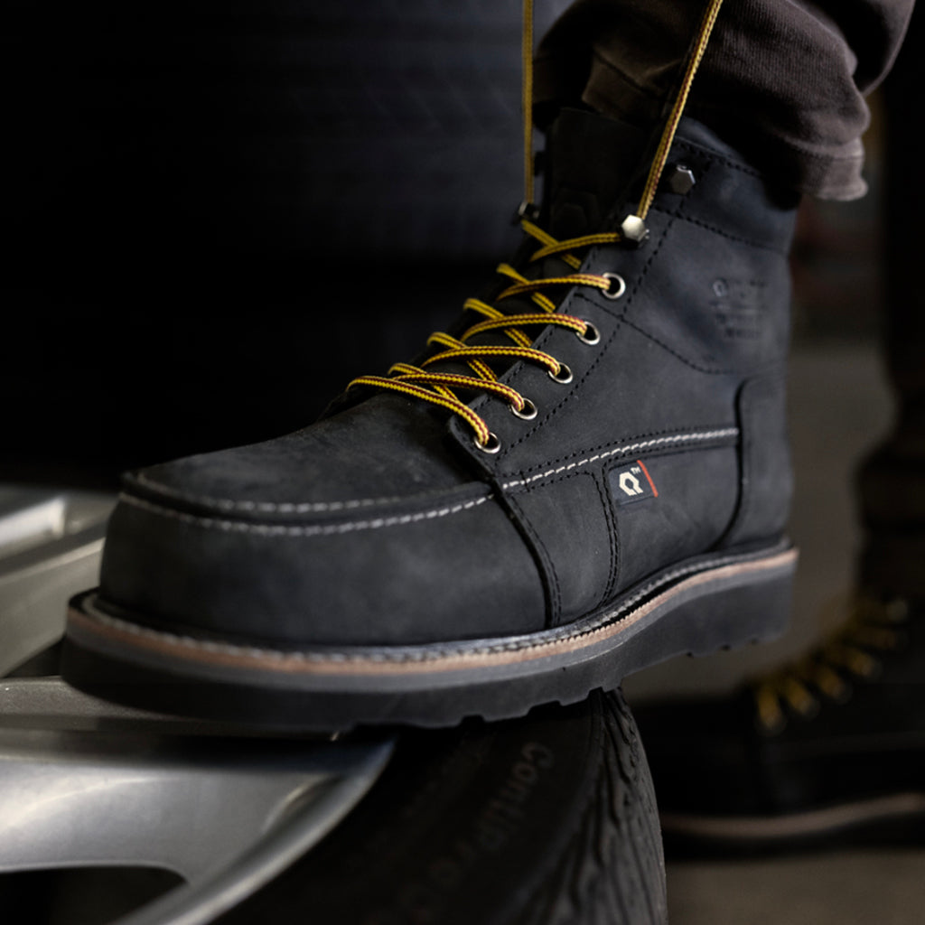 Black Steel Toe Work Boots standing on tire